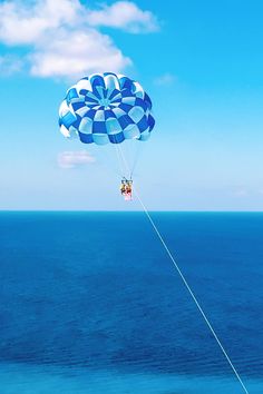 a person is parasailing over the ocean on a sunny day