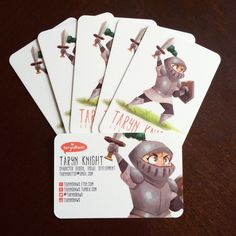 four cards with cartoon characters on them sitting on top of a wooden table next to each other