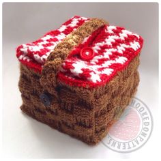 a red and white handbag hanging from a rope on top of a white table