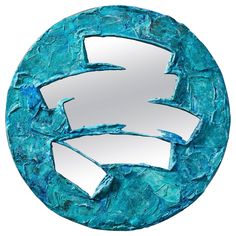 a circular mirror with blue paint and white paper cut out into the shape of an arrow