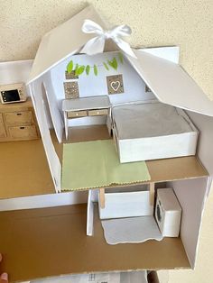 a doll house made out of cardboard with furniture inside