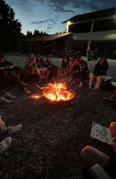 people sitting around a fire pit at night