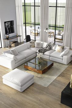 a living room with white furniture and large windows