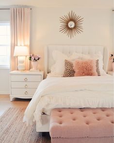 a bedroom with white furniture and pink accents