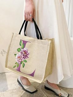 a woman holding a bag with flowers on it