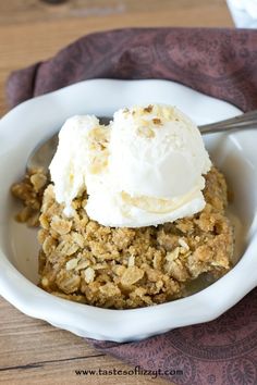 a close up of a bowl of food with ice cream on top and spoon in it