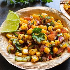 corn salad with cilantro and lime in a wicker bowl on a table