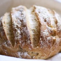 a loaf of bread sitting on top of a white paper bag covered in powdered sugar