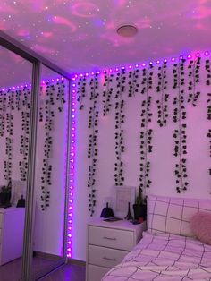 a bed room with a neatly made bed and purple lights