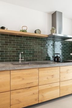 a kitchen with wooden cabinets and green tile backsplash