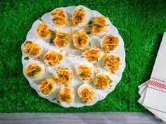 deviled eggs are arranged on a paper plate and placed on the grass with napkins