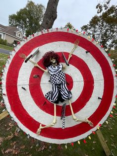 a fake skeleton is posed in front of a bulls eye target with a fork and knife on it