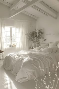 a bedroom with white walls and flooring has a bed covered in white linens