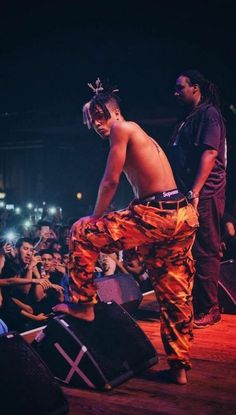 a man standing on top of a wooden floor in front of a crowd