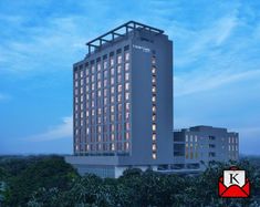 the hotel is lit up at night in front of trees and blue sky with white clouds