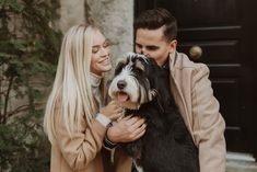 a man and woman are holding a dog