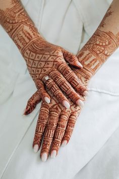 the hands of a woman with henna on them