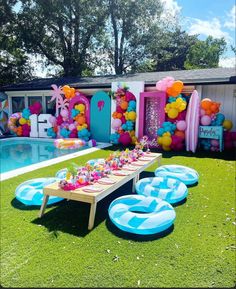 an inflatable pool is set up for a birthday party with balloons and decorations