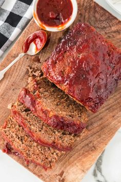 slices of meatloaf on a cutting board with sauces