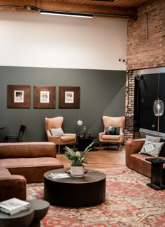 a living room with couches, chairs and a coffee table in front of a brick wall