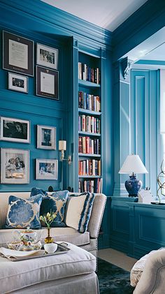 a living room filled with furniture and bookshelves covered in lots of bookcases