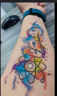 a person's arm with colorful ink on it and an object in the background