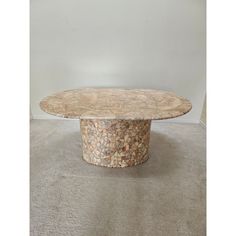 a round table made out of shells on carpeted floor next to white wall and door