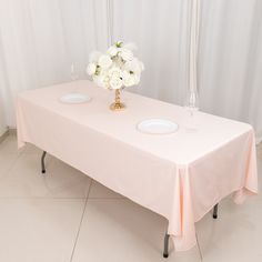 there is a table with two plates on it and flowers in the vase next to it