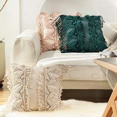 a white couch with pillows on top of it and a table in front of it