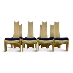 four wooden chairs with blue cushions are lined up against each other on a white background