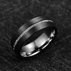 a black and white photo of a wedding ring with silver glitter inlays on it