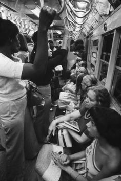 black and white photograph of people on subway train