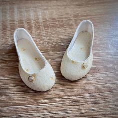 a pair of white shoes sitting on top of a wooden floor