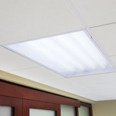 an overhead light fixture hangs from the ceiling in this office space with sliding glass doors