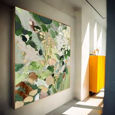 a painting hanging on the wall next to a yellow cabinet