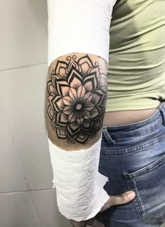 a woman with a black and white tattoo on her arm holding a roll of toilet paper