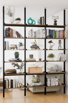 a bookshelf filled with lots of books on top of wooden floors