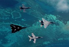 four fighter jets are flying in formation over the blue water and coral reefes,