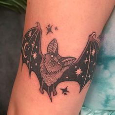 a small bat tattoo on the right arm and leg, with stars all over it