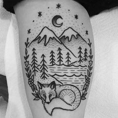 a tattoo on the leg of a person with a fox and mountains in the background