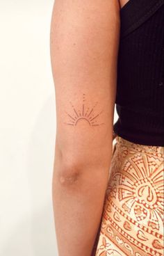 a woman with a sun tattoo on her arm