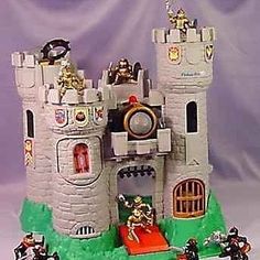 a toy castle with knights on the front and side walls, surrounded by other toys