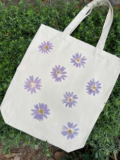 The Daisy Tote Bag is made witth real California daisies foraged in my neighborhood and hammered into canvas for the pigment to transfer. Makes a great gift! Can be done with any type of flower (if sourcing allows). Made in batches, each bag is unique, some flowers may not transfer as "perfectly" as shown here. Simple Bag Design Ideas, Tout Bag Ideas, Tote Bag Painting Ideas Flowers, Canvas Tote Bag Ideas, Simple Tote Bag Design, Tote Bag Decoration, Diy Bag Painting, Painted Canvas Bags, Handpainted Tote Bags