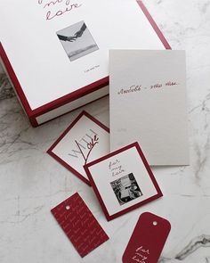 some red and white cards are laying on a marble counter top next to each other