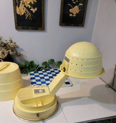 a yellow hard hat sitting on top of a counter next to two boxes and flowers