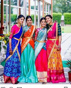 three women standing next to each other in colorful dresses