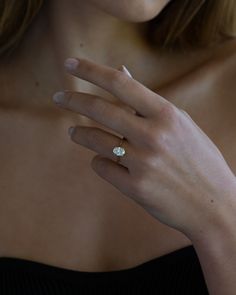 a close up of a person wearing a ring with a diamond on it's finger