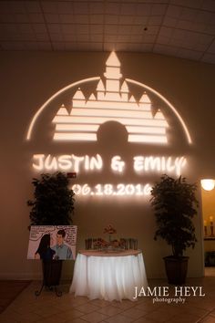 an illuminated sign in the shape of a castle with two people standing under it,