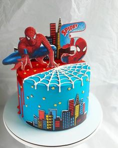 a spiderman themed birthday cake with the city skyline and skyscrapers in the background