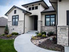 a house that is in the middle of some grass and flowers on the front lawn